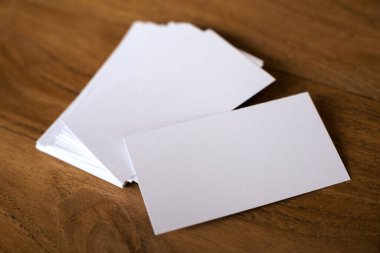 Ahşap masa arkasındaki kartvizit yığını