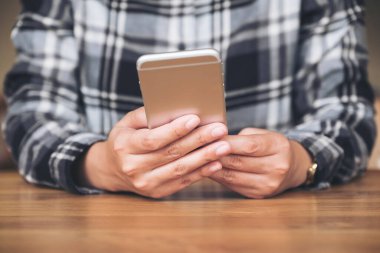 Elinde tutan, kullanan ve akıllı telefona bakan bir kadının yakın plan görüntüsü. 