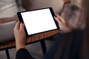 Kafe 'de elinde boş beyaz masaüstü ekranı olan siyah tablet bir kadının görüntüsü