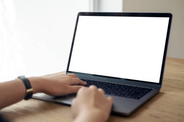 Boş beyaz masaüstü ekran ve ahşap masa üzerinde kullanılan ve yazan ellerin görüntüsü