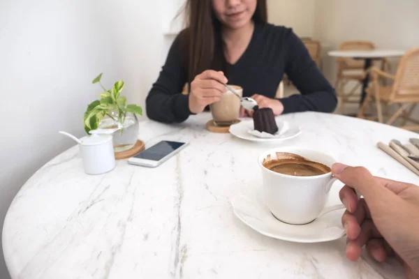 Close Afbeelding Van Een Hand Houden Koffiebeker Een Vrouw Eten — Stockfoto
