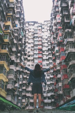 Quarry Bay, Hong Kong 'daki kalabalık yerleşim yerinin arasında duran güzel bir Asyalı kadın.