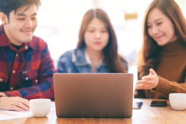 Üç Asyalı işadamı bir toplantıda birlikte çalışıyor ve iş tartışıyorlar.