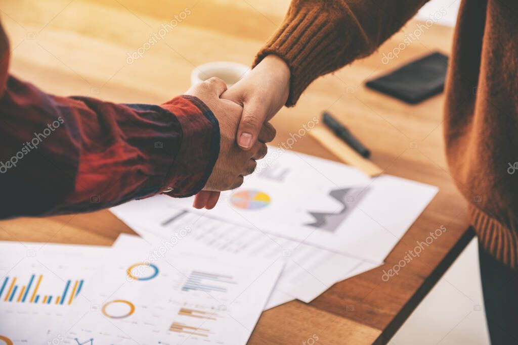 Closeup image of two businessman shaking hands after the meeting