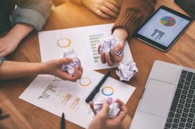 Bir işadamı, bir toplantıda masadaki kağıtları, tableti ve kağıtları elle karıştırdı.