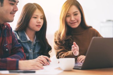 Üç Asyalı işadamı bir toplantıda çalışıyor ve sunum yapıyorlar.