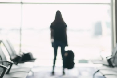 Havaalanında sırt çantalı bir kadın gezginin bulanık görüntüsü.