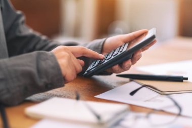 İş toplantısında hesap makinesi kullanan bir iş adamının yakın plan görüntüsü