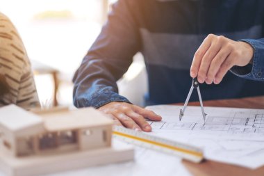 Ofiste çizim ve ölçüm için pusula kullanan bir mimar
