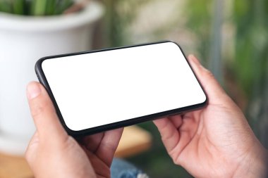 Siyah cep telefonunu boş ekran ile tutan ellerin görüntüsü