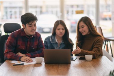 Üç Asyalı işadamı bir toplantıda çalışıyor ve sunum yapıyorlar.