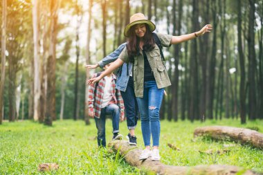 Bir grup gezgin ormanda yürürken kütükte yürüyor.