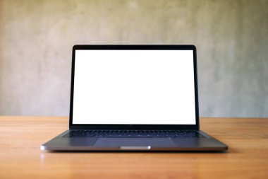 Boş beyaz masaüstü ekranlı dizüstü bilgisayarın beton duvar arkaplanlı görüntüsü