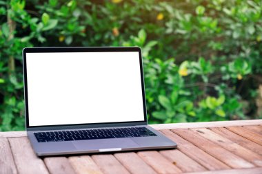 Tahta masadaki boş beyaz masaüstü ekranlı dizüstü bilgisayarın görüntüsü 