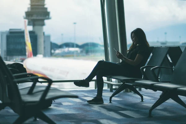 Žena Cestující Pomocí Mobilního Telefonu Zatímco Sedí Letišti — Stock fotografie