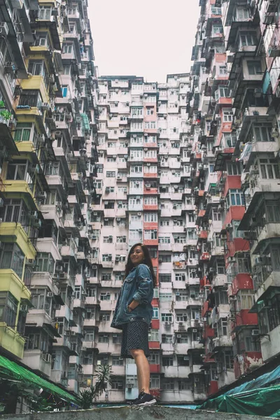 A beautiful asian woman standing among the crowded residential building of the community in Quarry Bay, Hong Kong