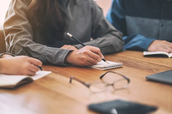 Imagen Cerca Muchas Personas Que Escriben Cuaderno Blanco Juntos Mesa — Foto de Stock