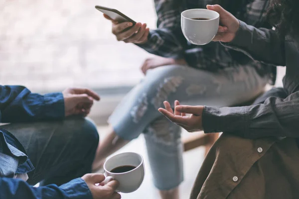 People using phone, talking and drinking coffee together