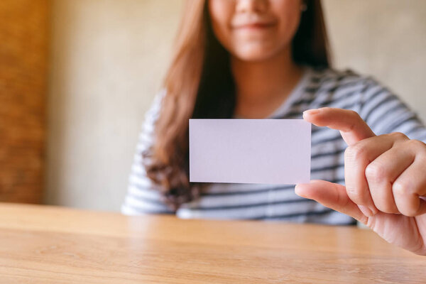 Женщина держит и показывает пустую визитку