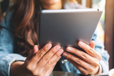Tablet bilgisayar kullanan ve elinde tutan bir kadının yakın plan görüntüsü