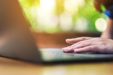 Laptop dokunmatik ped kullanan ve dokunan bir kadının yakın plan görüntüsü 