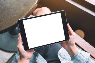 Üst görünüm, elinde beyaz ekranlı siyah tablet tutan bir kadının görüntüsü 