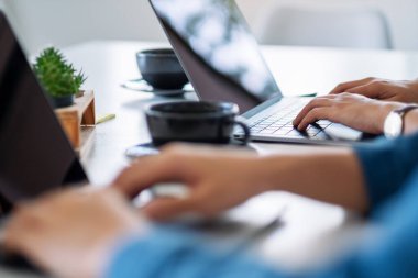 Ofiste dizüstü bilgisayar kullanan ve çalışan iş adamlarının yakın plan fotoğrafı.