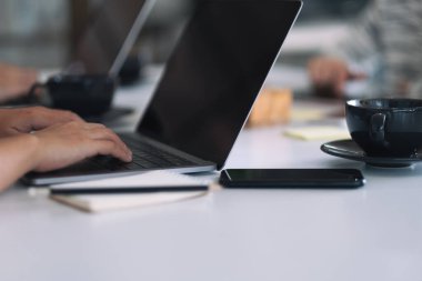 Ofiste dizüstü bilgisayar kullanan ve çalışan iş adamlarının yakın plan fotoğrafı.