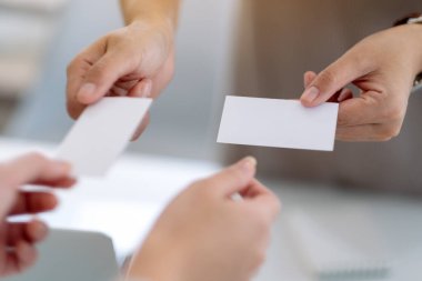 İki işadamı boş kartvizitlerini alıp değiş tokuş ediyor. 
