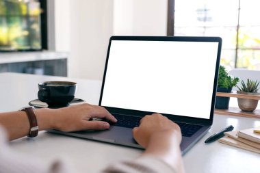 Boş beyaz masaüstü ekranı ve tahta masası üzerinde yazı yazan ve kullanan bir kadının görüntüsü