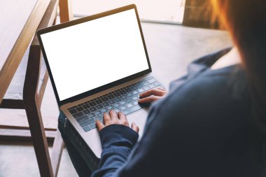 Laptop bilgisayar klavyesinde boş beyaz masaüstü ekran kullanan ve yazan bir kadının görüntüsü 