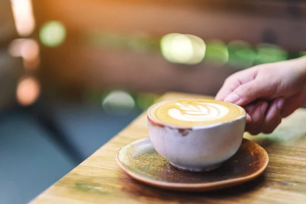 Kobieta Trzymająca Filiżankę Gorącej Kawy Latte Drewnianym Stole Rano — Zdjęcie stockowe