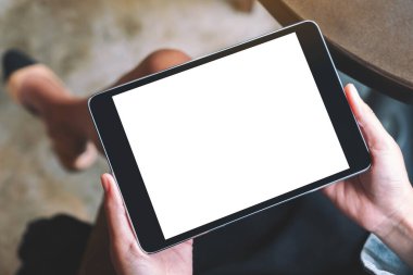 Üst görünüm, elinde beyaz ekranlı siyah tablet tutan bir kadının görüntüsü 