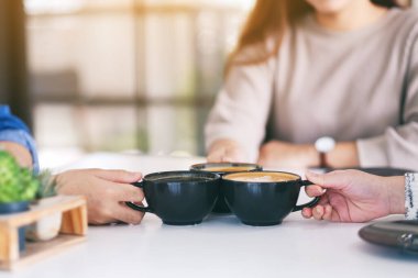İnsanların yakın plan görüntüsü, kafedeki kahve fincanlarını tokuşturmayı ve içmeyi seviyordu.