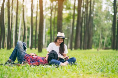Genç Asyalı bir çift parkta birlikte oturup yatıyorlar.