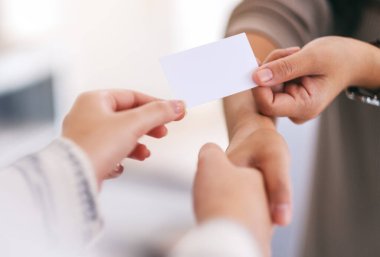 İki insan el sıkışıyor ve birbirlerine boş kartvizit veriyorlar. 