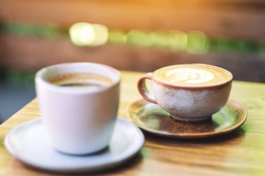 İki fincan sıcak kahve ve ahşap masada Amerikan kahvesinin yakın plan görüntüsü. 