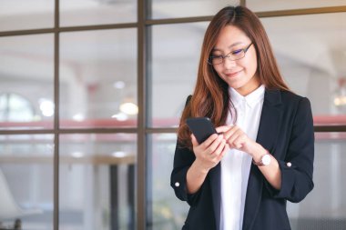 Cep telefonu tutan ve kullanan bir iş kadınının yakın plan görüntüsü