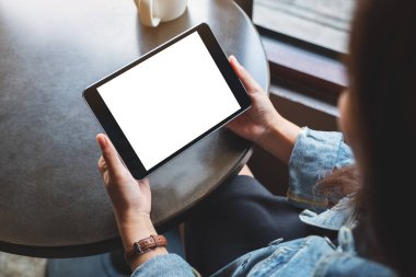 Siyah tablet taşıyan beyaz ekranlı bir kadının görüntüsü. 