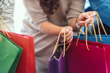 Alışveriş çantalarını bir arada tutan insanların yakın çekimi.