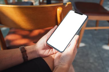 Boş masaüstü ekranı olan siyah cep telefonunu tutan ellerin görüntüsü 