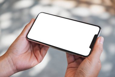 Boş masaüstü ekranı olan siyah cep telefonunu tutan ellerin görüntüsü 