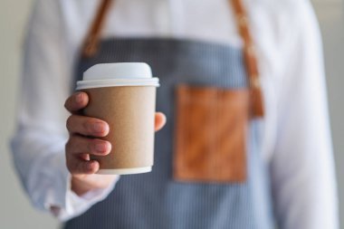 Bir garson kafede bir fincan sıcak kahve ikram ediyor.