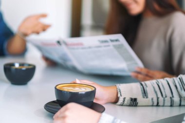 İnsanların konuştuğu, gazete okuduğu ve sabahları kahve içtiği yakın plan görüntüler.