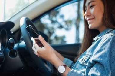 Araba kullanırken cep telefonu kullanan bir kadının yakın plan görüntüsü