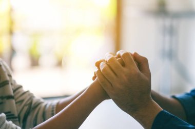 Sevgi ve ilgi göstermek için bir kadının elini tutan bir erkek.