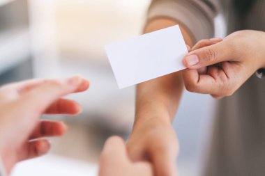 İki insan el sıkışıyor ve birbirlerine boş kartvizit veriyorlar. 