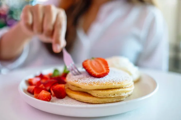 Eine Frau Hält Und Isst Pfannkuchen Mit Erdbeeren Und Schlagsahne — Stockfoto