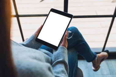 Siyah tabletli beyaz ekranlı bir kadının görüntüsü. 