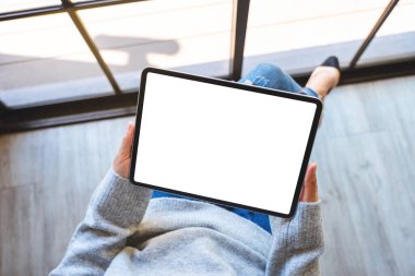 Siyah tabletli beyaz ekranlı bir kadının üst görünüm görüntüsü 